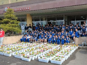 雄志中学校での環境美化活動の様子（プランターと生徒の写真）