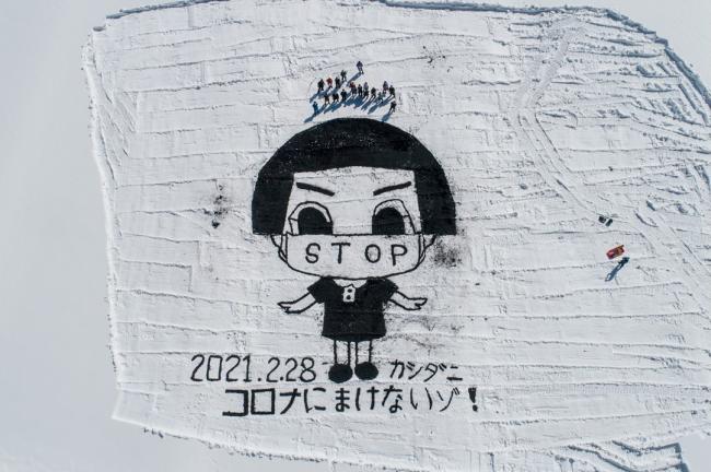ドローンに向かって皆で手を振る写真
