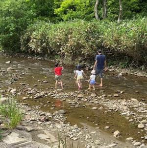 川遊びをする田中さん家族（写真）