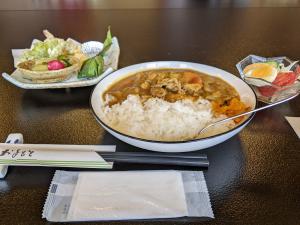 昼食のカレー、山菜天ぷらなどの写真