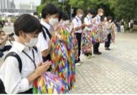折り鶴を手に合掌する中学生（写真）
