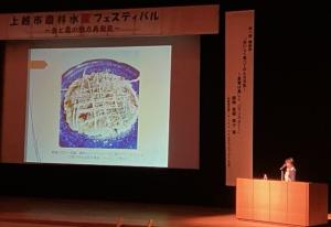 プロジェクターの内容を説明している様子（写真）