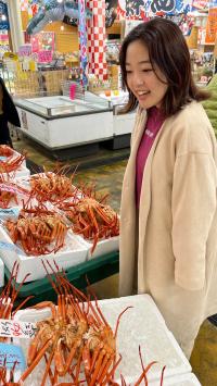 鮮魚店で買い物をしている内田さん（写真）