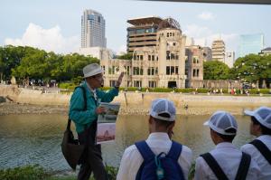 平和記念公園でガイドさんから説明を受けている様子（写真）