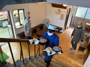 2階の食堂へそばを運ぶ（写真）
