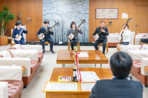 津軽三味線・津軽民謡全国大会で優勝した津軽三味線グループ「いちこつ」による報告の写真