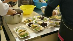 つきたての餅に味付けをする様子(写真）