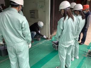 高校生が塗装作業を教わる様子