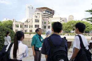 平和記念公園でガイドさんから説明を受けている様子(写真)