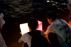 生徒が作成した灯ろうを流す様子(写真)