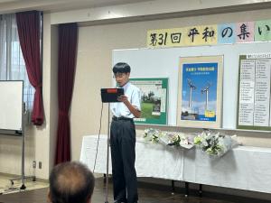 生徒が派遣報告と平和の誓いを述べている様子(写真)
