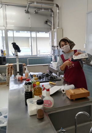 押し寿司に使用する牛乳パックの切り方の説明をする講師（写真）