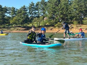 カヌーに乗り笑顔でピースサインをする子どもの様子（写真）