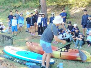 カヌーに乗る前にこぎ方を教えてもらう様子（写真）