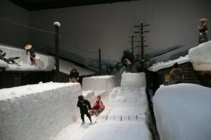 昔の人が屋根の雪下ろしをしたり、雪が積もった道をソリに人を乗せて通る様子を表現したジオラマ