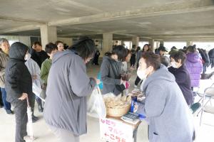 加工グループのお母さんと話しながら購入する人の様子（写真）