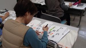 季節を意識した作品を書く受講者（写真）