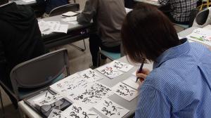 同じ文字を何度も練習する受講者（写真）