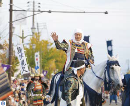 （写真10）出陣行列で白馬に乗り沿道に手を振る謙信公役の松平健さん