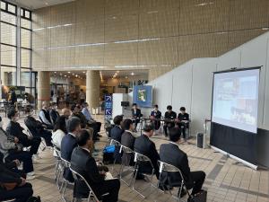 生徒たちの説明を聞く来場者の様子（写真）