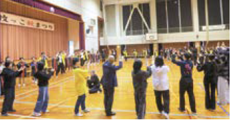 子どもたちと来場者が輪になって踊る様子（写真）