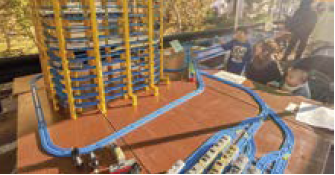 おもちゃの電車を使った企画を体験する親子（写真）