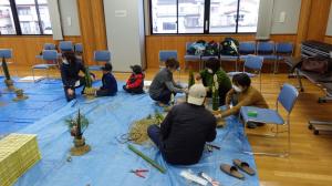 わらを編む作業を行う、門松作成の様子（写真）