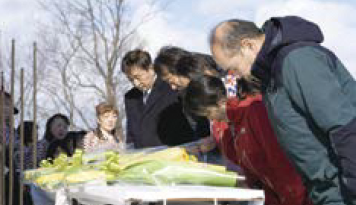 参加者がレルヒ像に献花を行う様子（写真）
