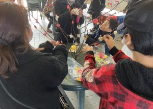 まゆ玉飾り作りを行う参加者の様子（家族、写真）
