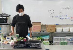 買ってきた食材の説明をする信田さん（写真）