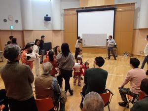 さまざまな国、年代の人が集まりゲームを楽しむ（写真）