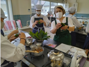 ちまきの巻き方を教える講師（写真）