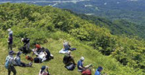 山頂でひと休みする参加者たち(写真)