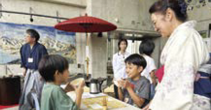 笑顔でお茶を飲む子ども（写真）