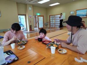 小さい子供と両親が美味しそうに食べる様子（写真）