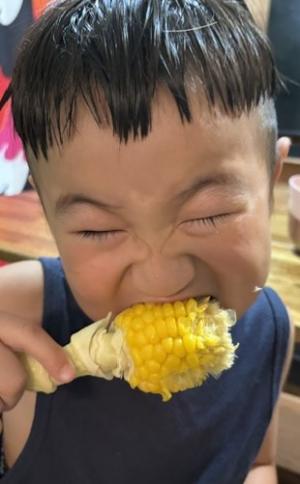 とうもろこしを頬張る男児（写真）