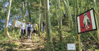 山道に飾られた作品と登山者(写真)